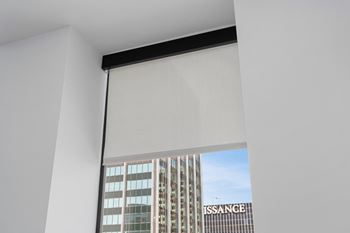 A white motorised blind in a window